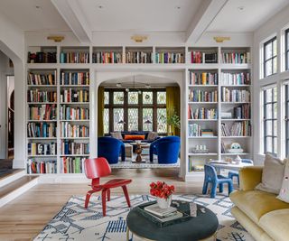 Living room with one wall of floor to ceiling bookcases as divider