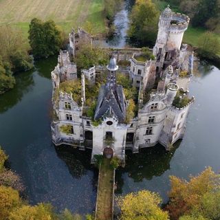 white castle surrounded with pond and green trees