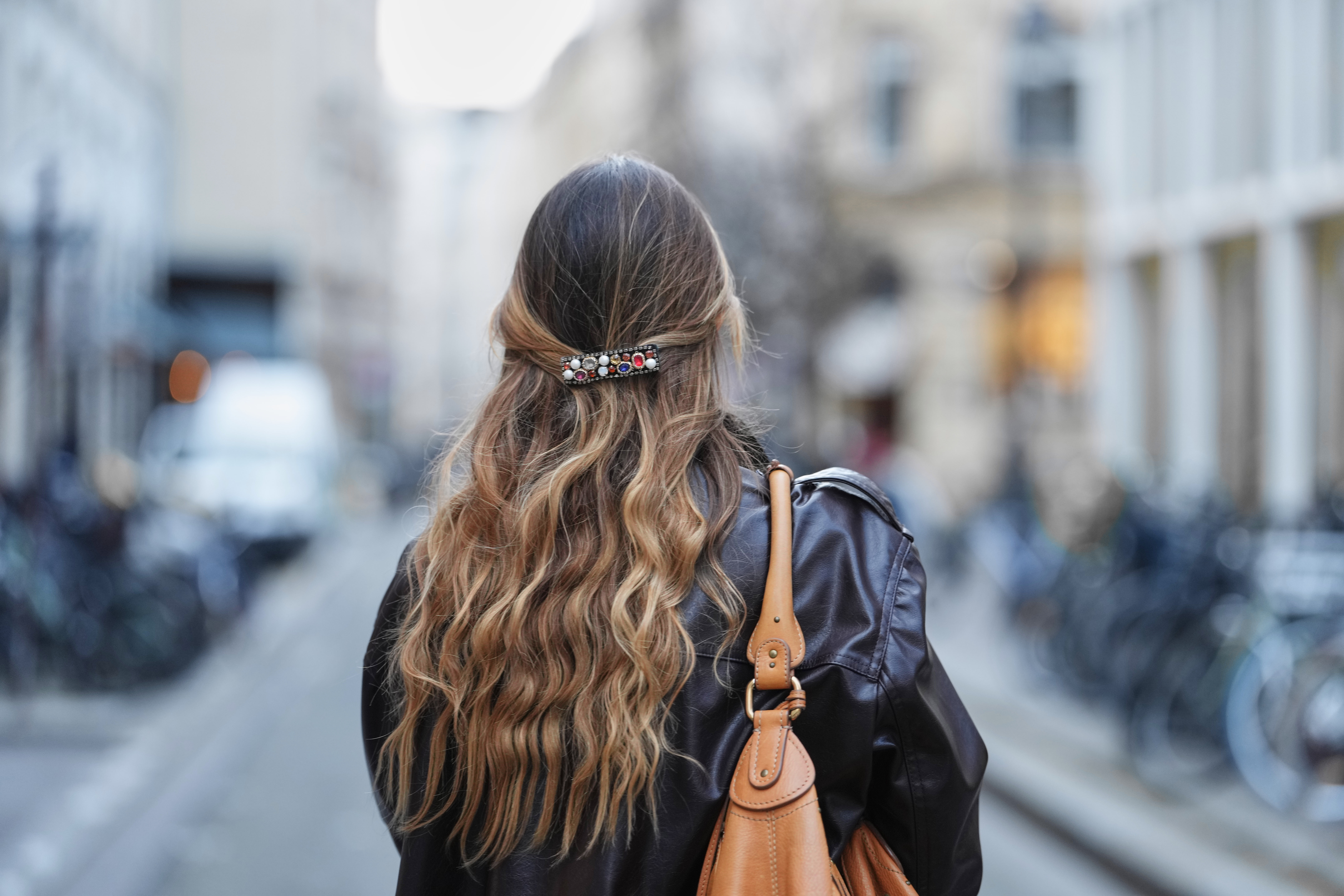 PARIS, FRANCE - FEBRUARY 04: Maria Rosaria Rizzo wears colored bejeweled hair clip, brown long wavy hair, a leather jacket, during a street style fashion photo session, on February 04, 2026 in Paris, France. (Photo by Edward Berthelot/Getty Images)
