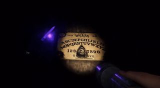 A screenshot from the Phasmophobia console reveal showing a flashlight illuminating a ouija board