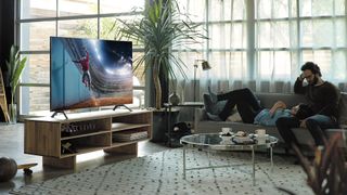 Man and woman on couch in front of big screen TV