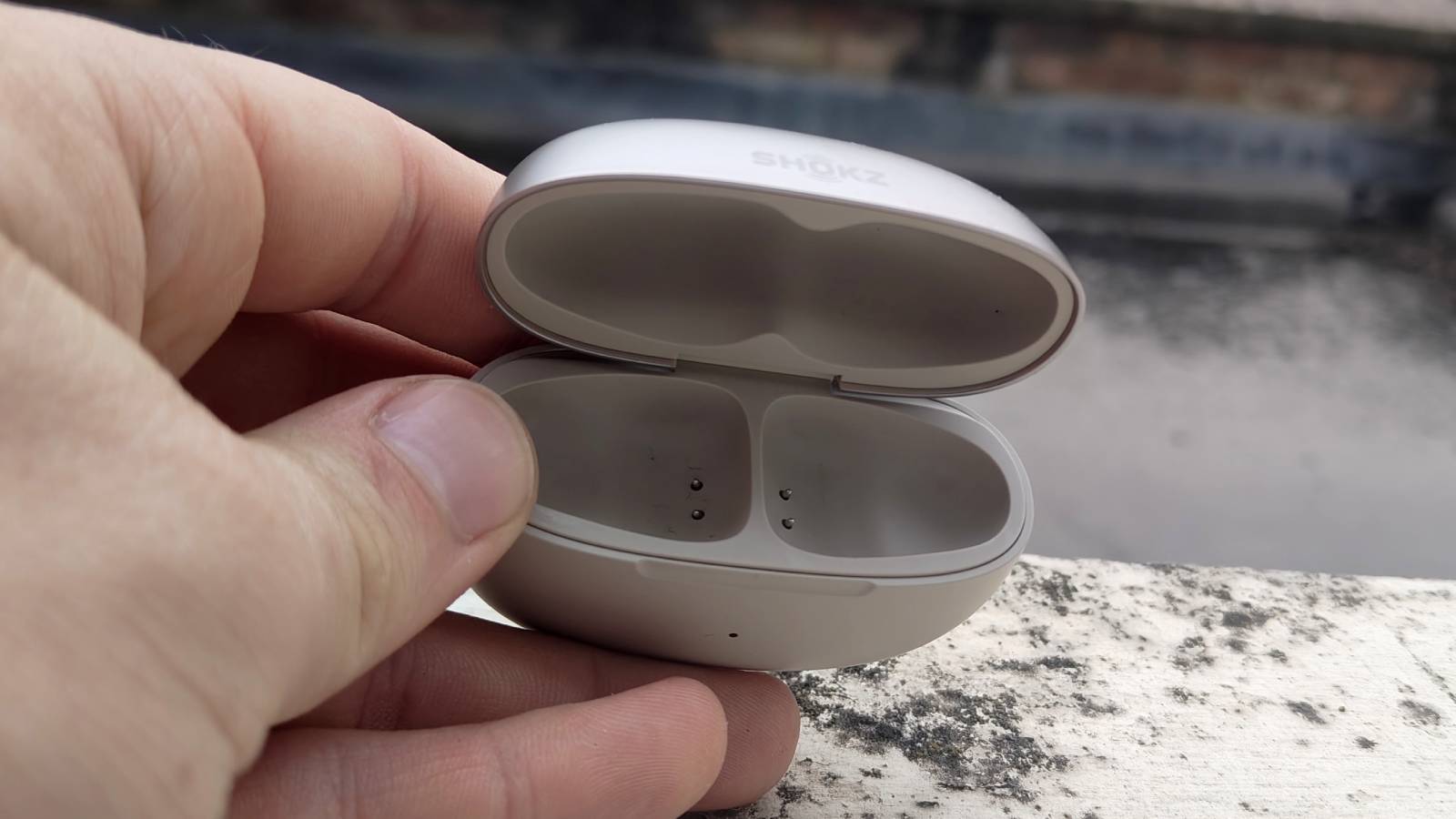 The Shokz OpenDots One on a white windowsill