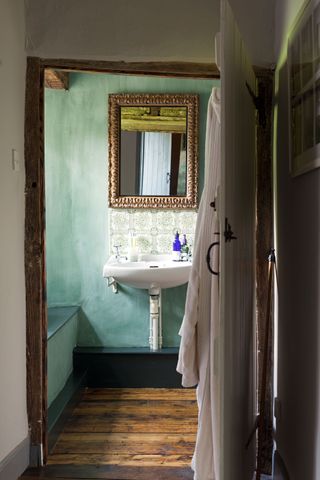 vintage blue bathroom with white sink and mirror