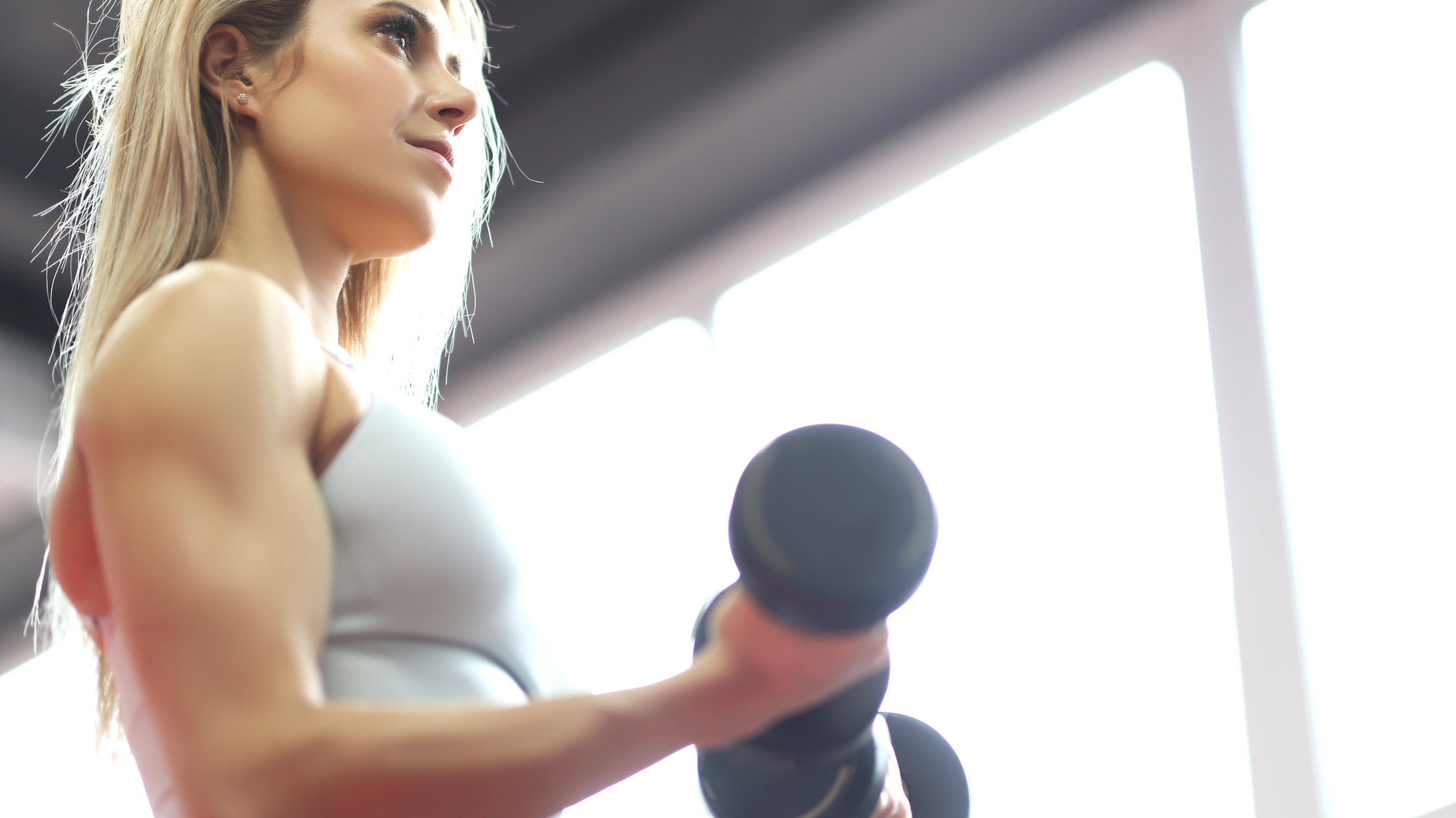 a woman performing bicep curls with two dumbbells