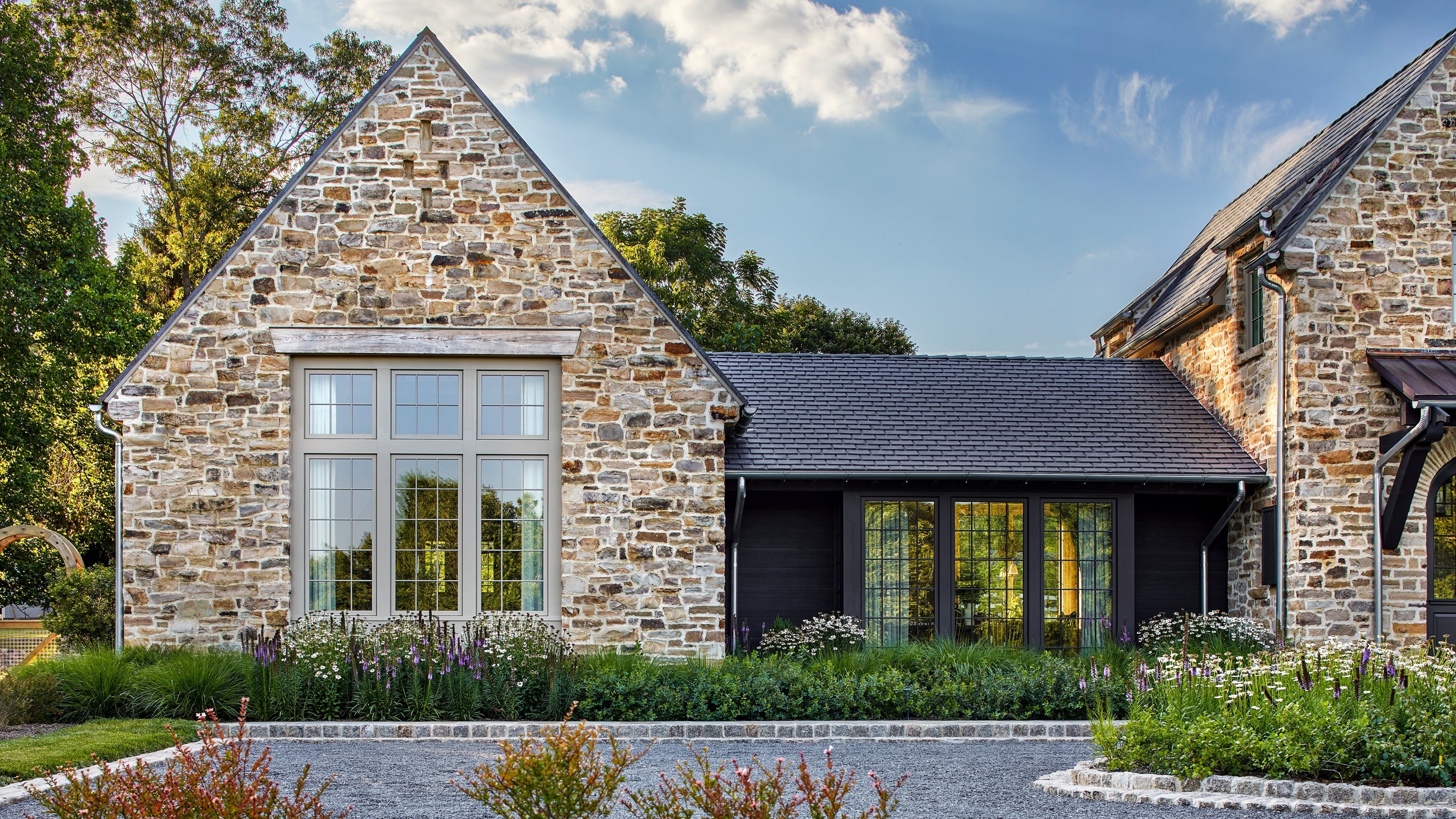 front of a house with a drive and attractive plantings