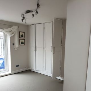white room with frames on wall and wardrobe