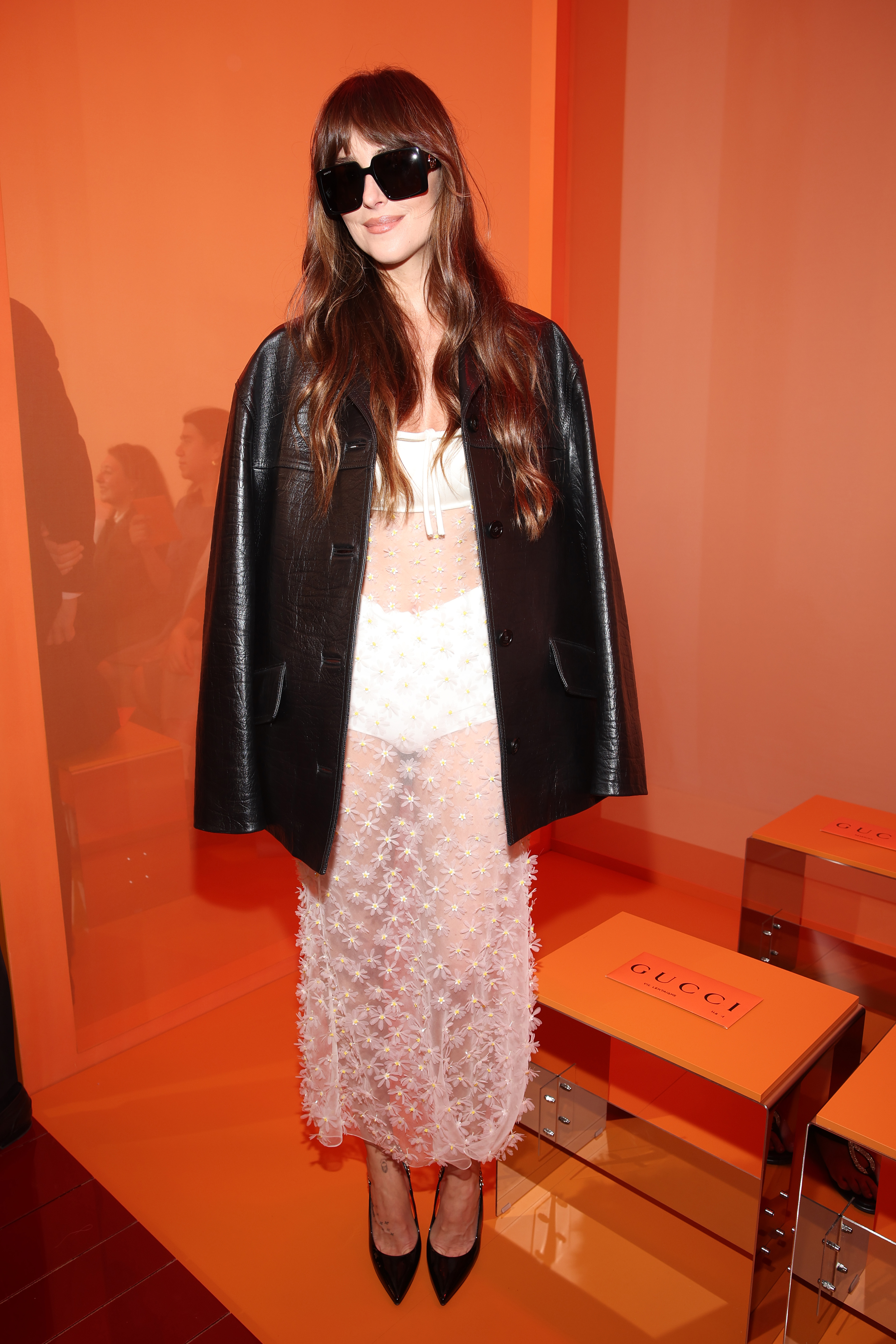 Dakota Johnson wearing a sheer dress with a leather jacket