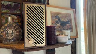 Tivoli Model Two Digital wireless speaker stood on end on busy wooden shelf