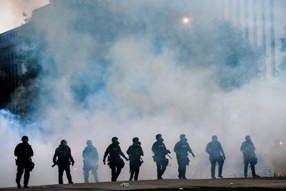 Police officers in Denver after firing tear gas.