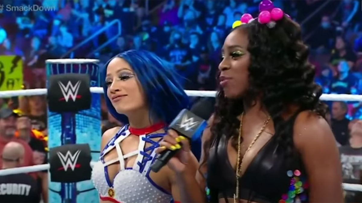 Sasha Banks and Naomi sharing a ring together and talking into the mic.