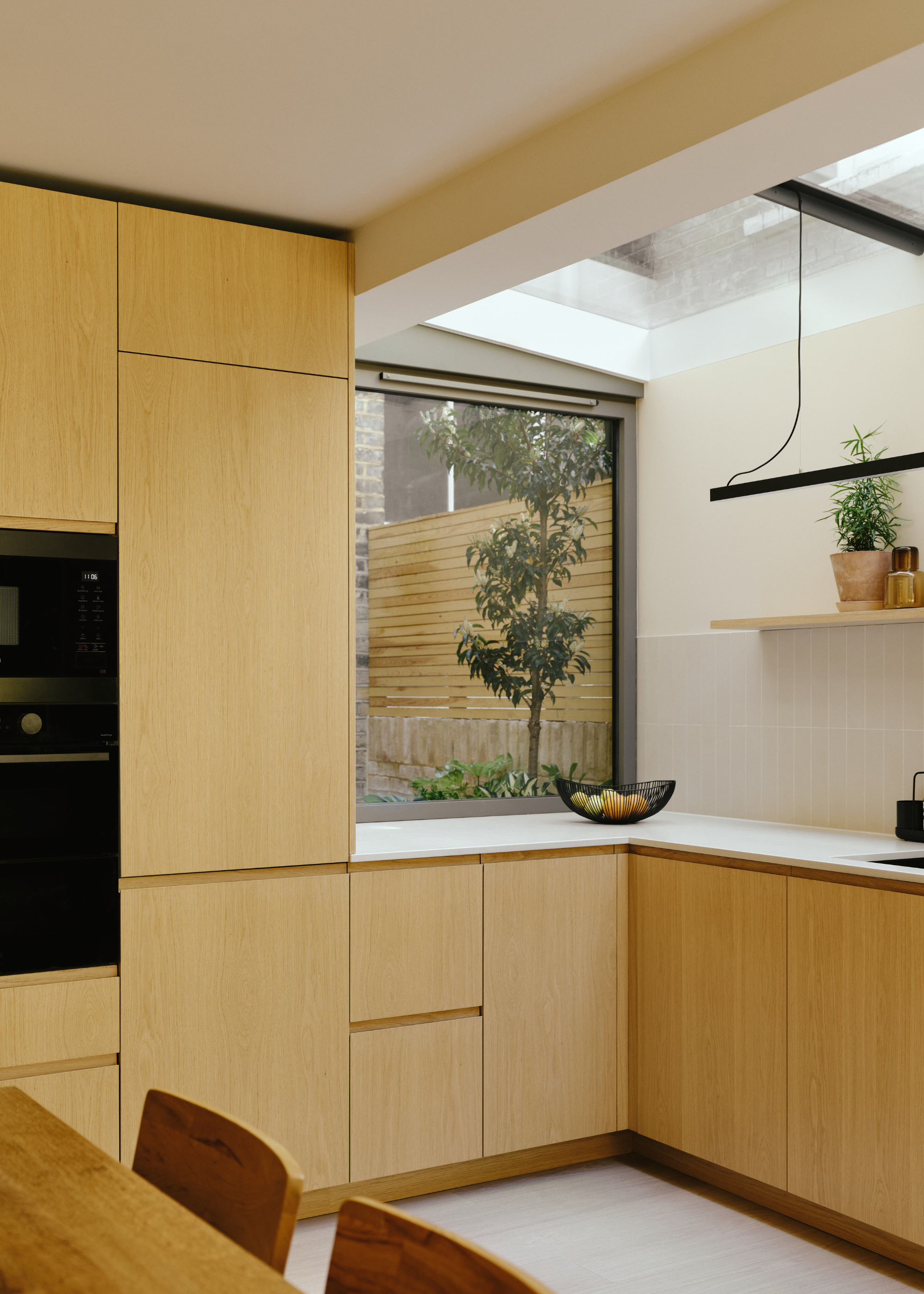 wooden fronted cabinets in a sleek, modern kitchen with plenty of natural light