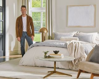 Nate Berkus standing infront of bed with his bedding collection