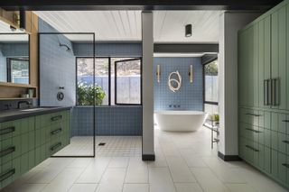 large bathroom with freestanding tub and dark framed shower screen