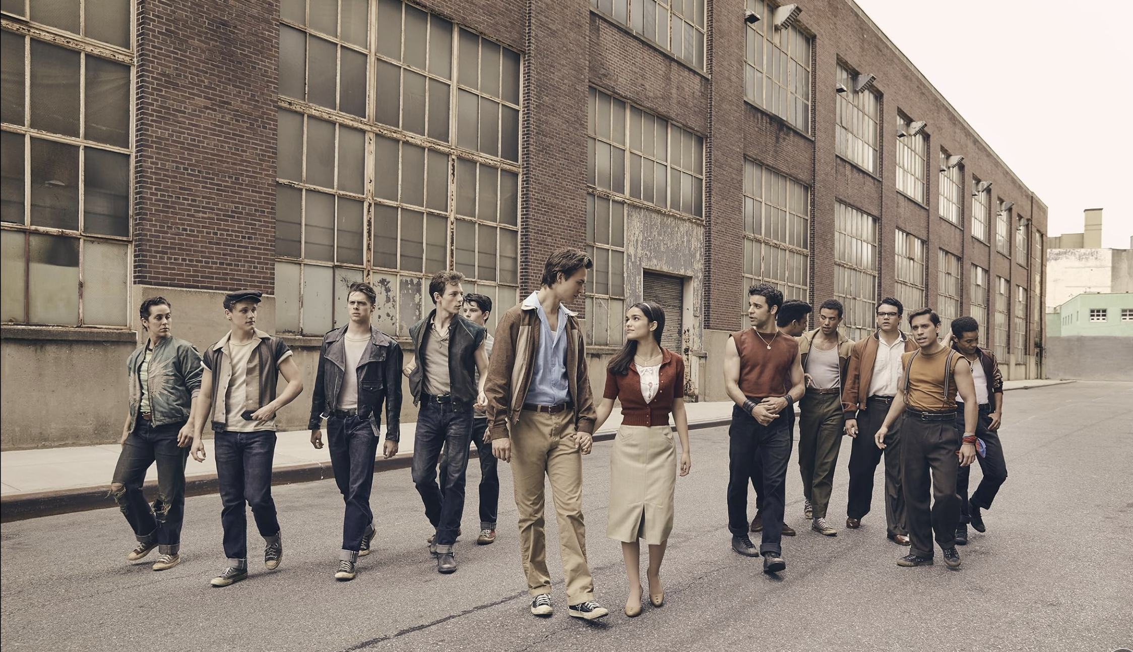 an image from West Side Story (2021) showing Tony and Maria in the centre, with the sharks and jets either side