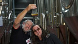 Alex Lifeson and Geddy Lee examining a beaker of beer at a brewery