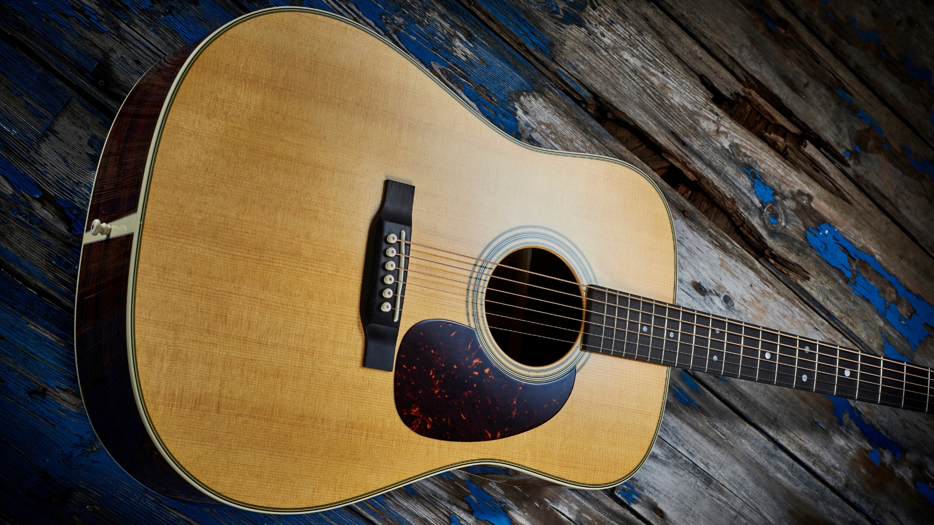 A Martin D-28 acoustic guitar lying on a distressed wooden floor