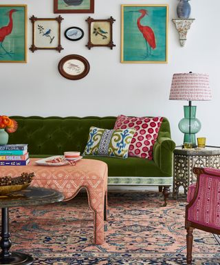 colorful living room with green sofa, pink armchair, salmon pink coffee table and artwork