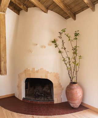 Living room area in home office featuring plant and traditional fireplace