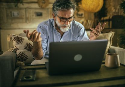Man sitting on a couch frustrated