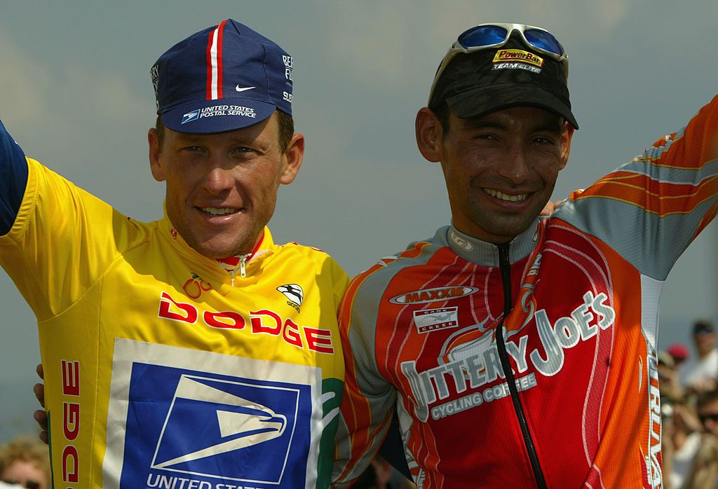 BRASSTOWN BALD GA APRIL 24 Cesar Grajales from Columbia riding for Jittery Joes Coffee takes the podium with Lance Armstrong of the US riding for US Postal Service presented by Berry Floor after Grajales won the stage and Armstrong defended the yellow jersey in Stage 6 of the Tour de Georgia on April 24 2004 in Brasstown Bald Georgia Photo by Colby KiddGetty Images