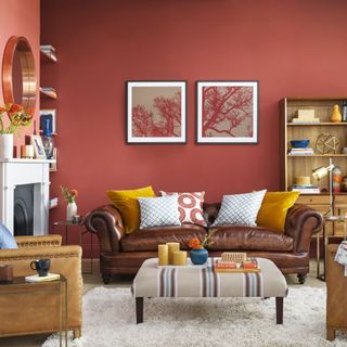 red living room with brown leather sofa and wooden bookcase