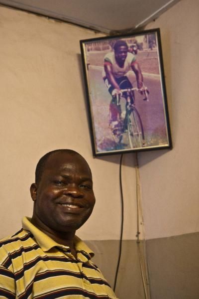 Mustafa Saka smiles proudly in his home with a photograph taken during his racing prime.
