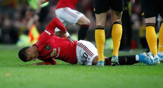 Marcus Rashford holds his back after suffering the injury against Wolves