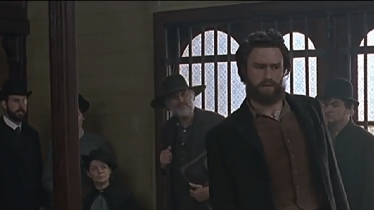 Heath Ledger with a beard addressing a crown in Ned Kelly