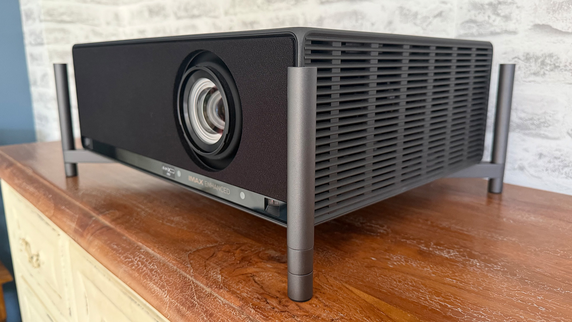 Xgimi Titan home cinema projector on wooden sideboard with legs attached, slight angle