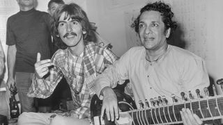 Beatle George Harrison, (L), listens as Ravi Shanker of India plays the sitar, 8/3, a 25-stringed guitar-like instrument.