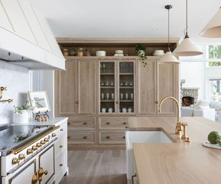 kitchen with wooden cabinets and white hood and range cooker