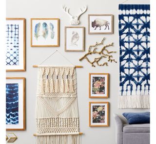 Target shibori gallery wall with macrame wall hanging, antler heads and wooden picture frames on wall