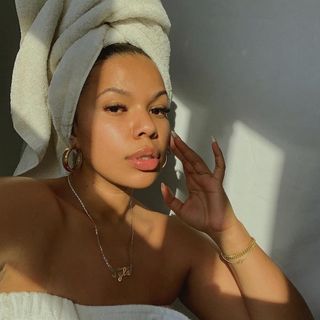 Woman wearing a towel and jewelry in sunlight