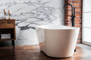 marble bathroom with white tub and tiled floor