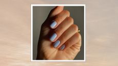 A close-up of a hand with pastel blue nails by nail artist, Mateja Novakovic (@matejanova), pictured in front of a grey background and in a beige to grey sunset-style template