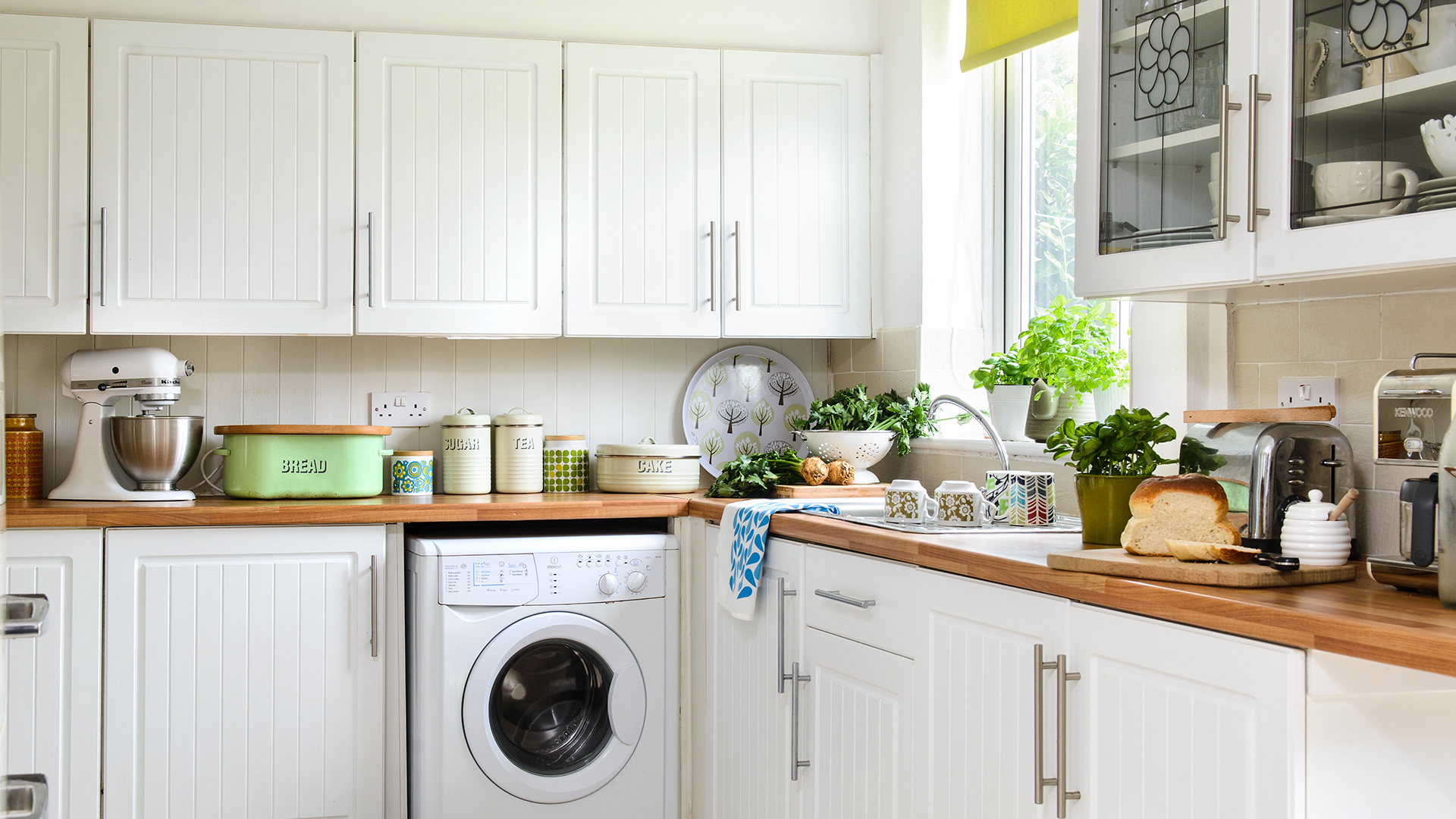 Cream kitchen with cluttered worktops with kitchen accessories and food
