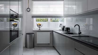 gray kitchen with stainless steel trash can