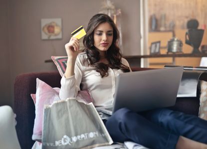 Sanitary products: Woman shopping online while holding credit card. Free stock photo from Unsplash