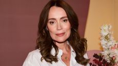 Keeley Hawes wearing a white shirt with glowing skin and tousled brown hair