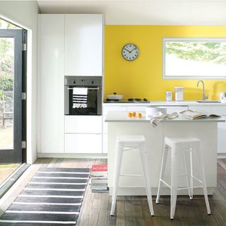 kitchen with white worktop and yellow wall