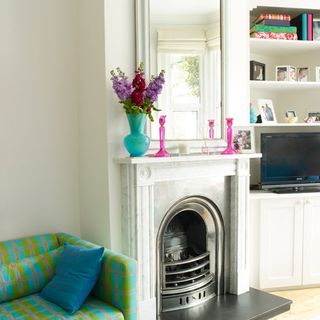 fireplace with flower vase and mirror on wall
