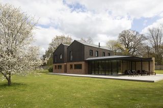 modern timber frame home with black cladding and brick