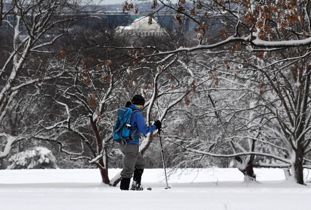 Man treks through snow.