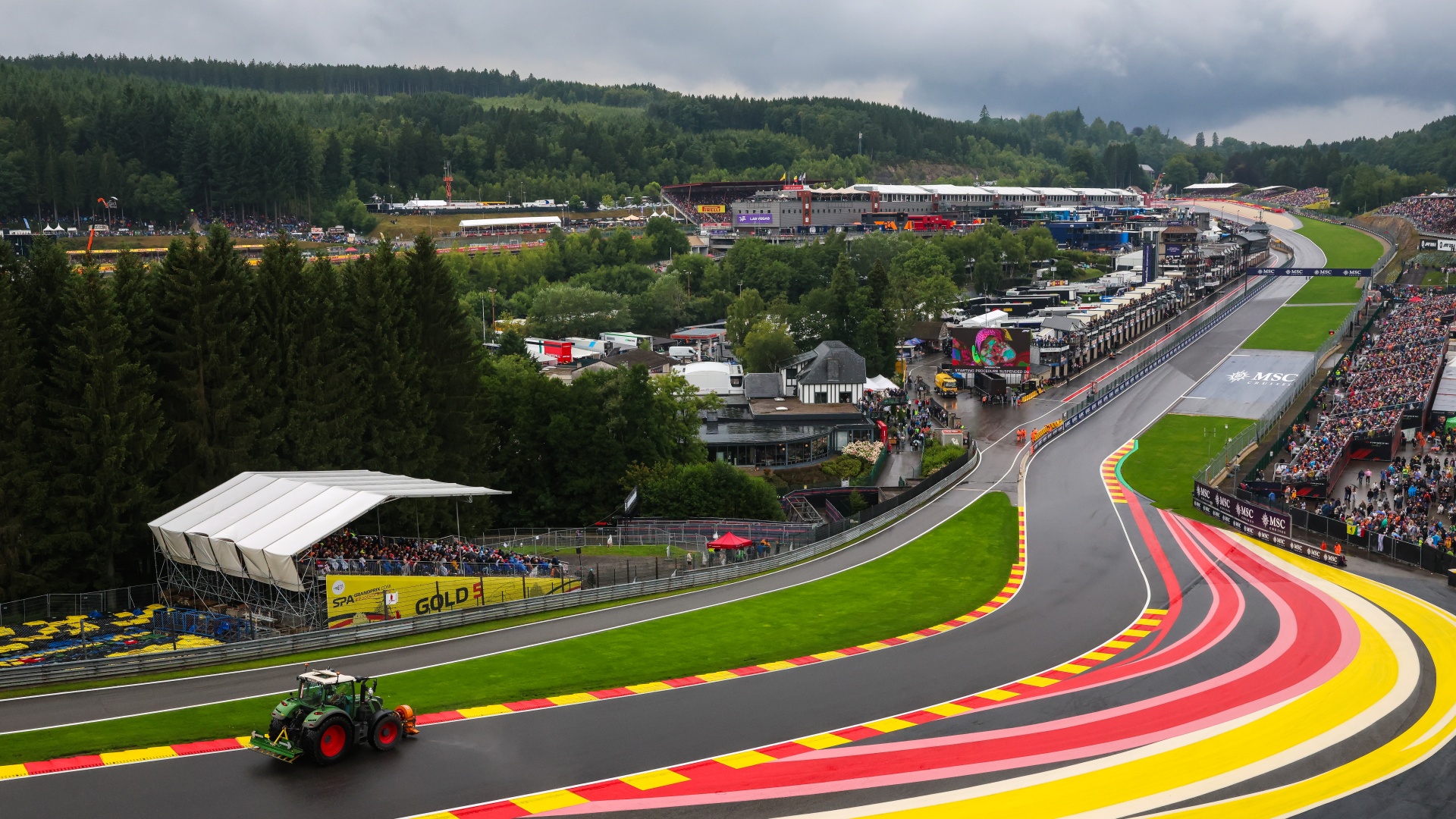 Tractors attempt to clear water off the racing line at Eau Rouge following a red flag during the Belgian Grand Prix at Circuit de Spa-Francorchamps in 2025