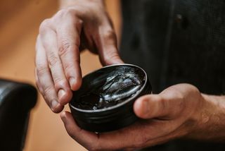 Image showing a man holding a tub of hair wax