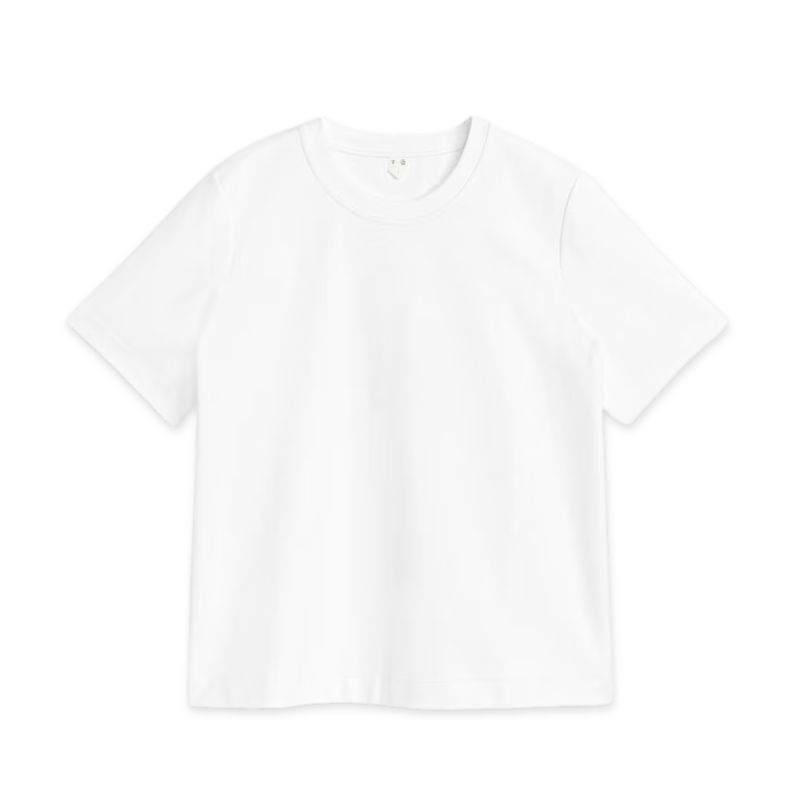 A cut out of a white t-shirt by Arket set against a white background