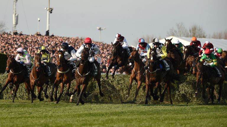 The runners and riders take a fence at the Aintree Grand National