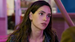 Adria Arjona, in a black leather jacket, staring in Hit Man (2023).