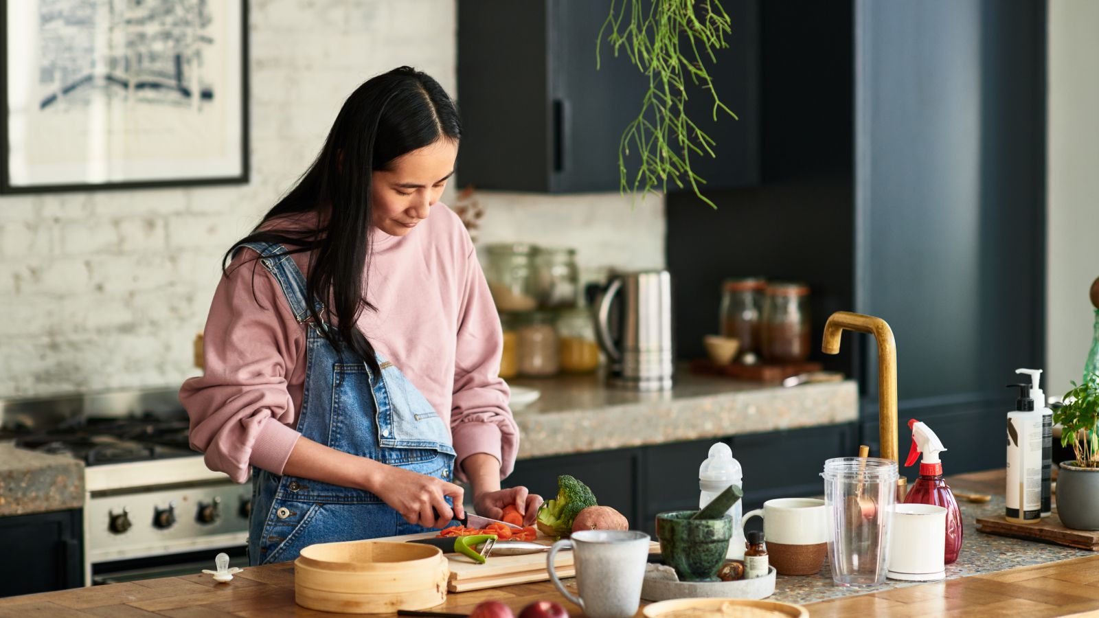 Mujer cocinando en casa con ingredientes frescos