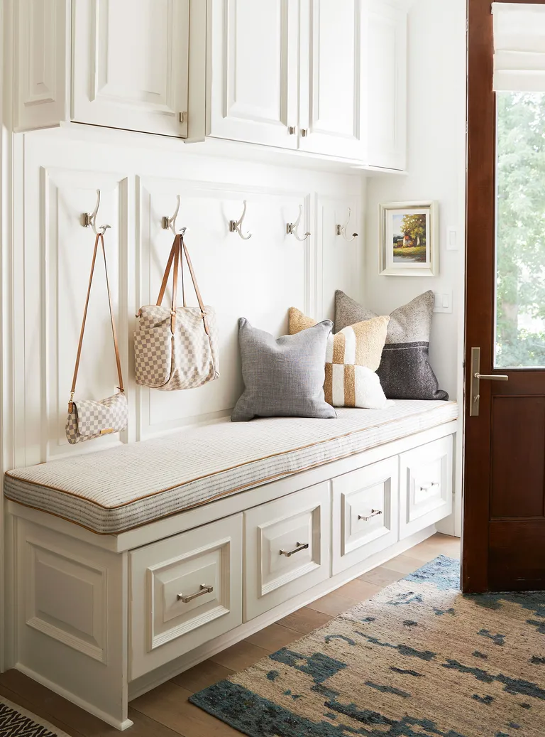 Small white entryway with bespoke storage and wood floor